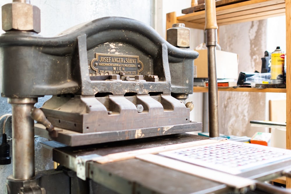 die Buchbinderei Wartberger hat traditionelle Geräte in der Werkstadt. Am Bild ist eine manuelle Druckerpresse zu sehen. 