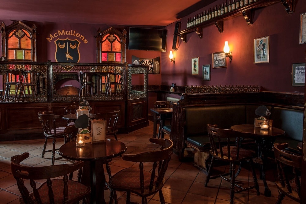 Inneneinrichtung aus dunklem Holz und dunkelroter Wandfarbe im McMullens Pub in Klagenfurt