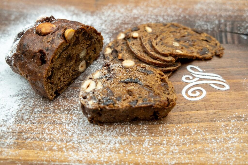 Früchtebrot aka Kletzenbrot der Bäckerei Taumberger, halb aufgeschnitten auf einem Holzbrett