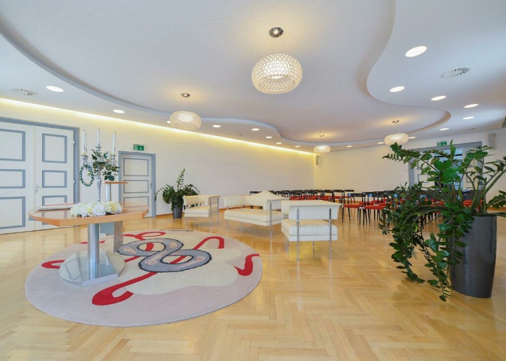 das Trauungszimmer im Standesamt in Klagenfurt am Wörthersee, geschmackvoll eingerichtet mit weißen und roten Möbeln bietet es genügend Platz für das Brautpaar und ihre Gefolgschaft