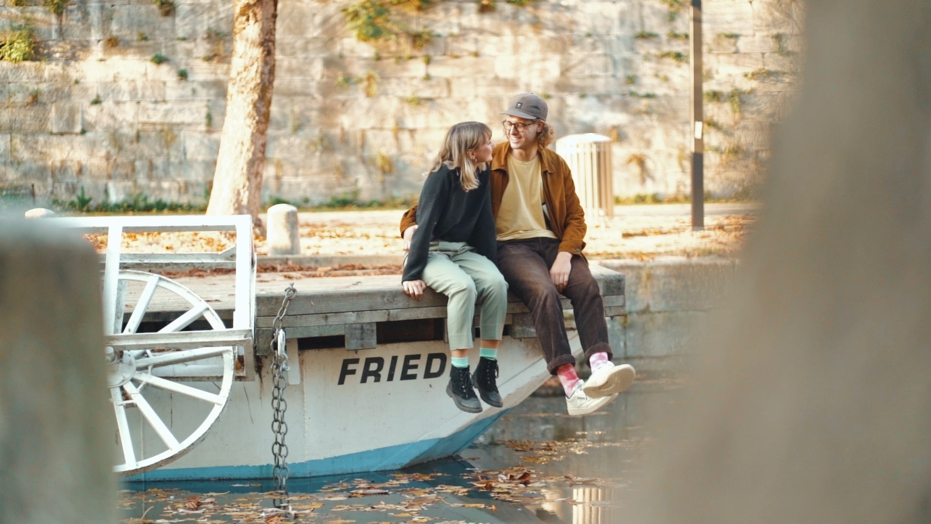 Verliebtes Paar im Herbst auf einem Boot sitzend am Lendkanal