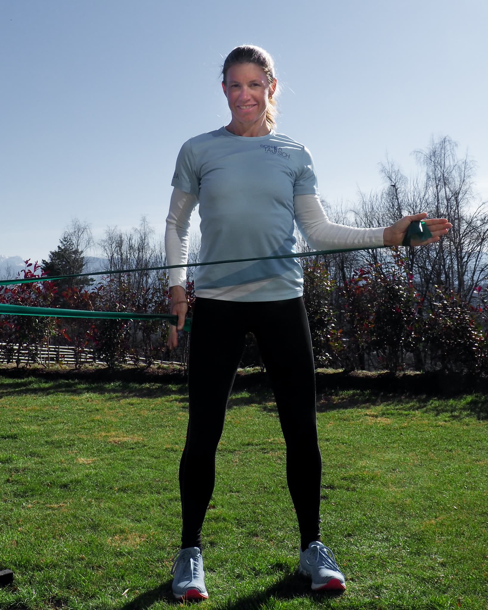 Triathletin Sonja Tajsich zeigt Außenrotation-Übung mit dem Theraband