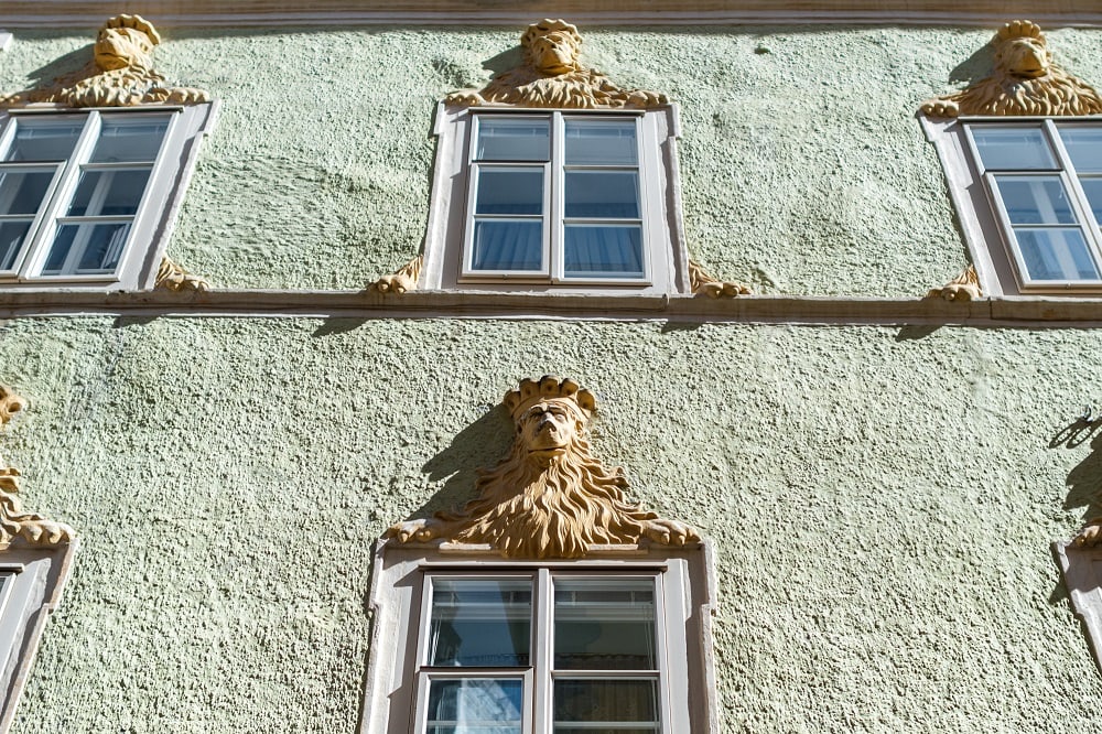 die Fassade eines Hauses in der Wienergasse, dessen Fenster mit Löwen-Reliefs gekrönt sind