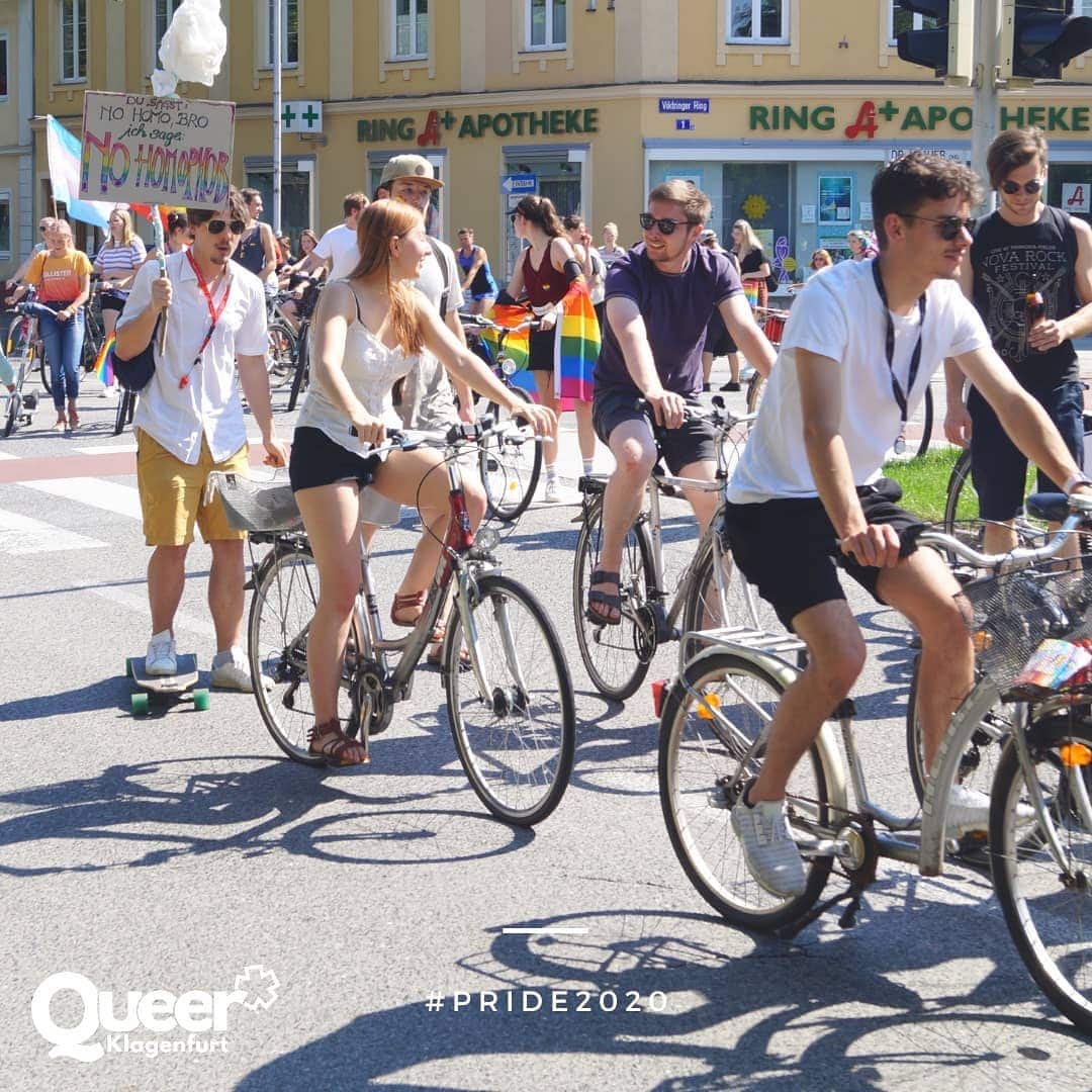 Schnappschuss der Fahrrade Regenbogenparade mit Frauen und Männern auf Fahrrädern, einige halten Regenbogenfahnen und Spruchtafeln in de Hand