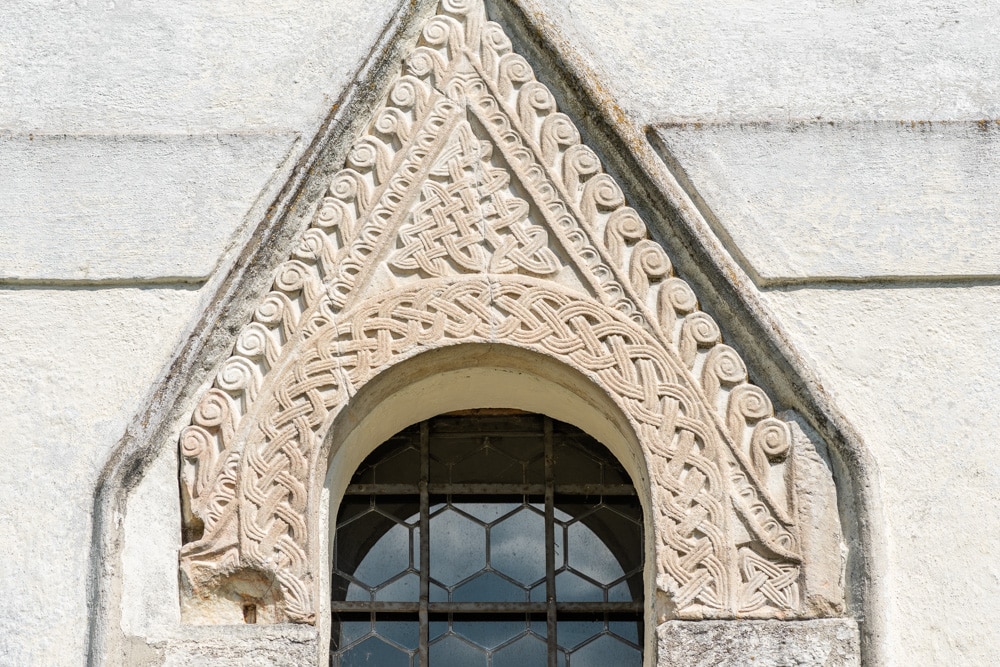 Auf der West-Fassade der Kirche sind über dem Kirchenportal zwei großartige karolingische Flechtwerksteine eingemauert