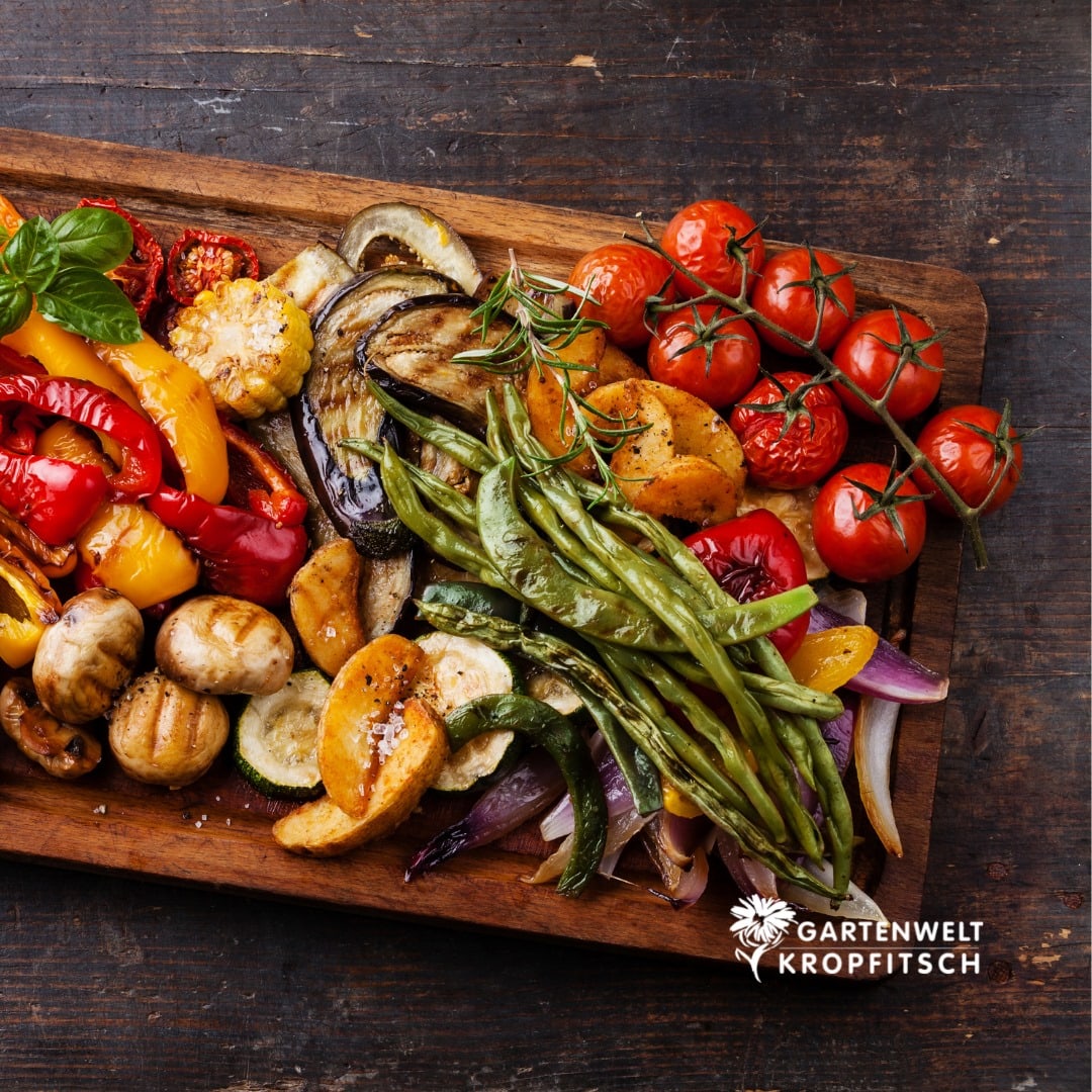 perfekt gegrilltes Gemüse mit einem Grill der Gartenwelt Kropfitsch auf einem Holzbrett angerichtet, Tomaten, Mais, Champignons, Kartoffel, Bohnen