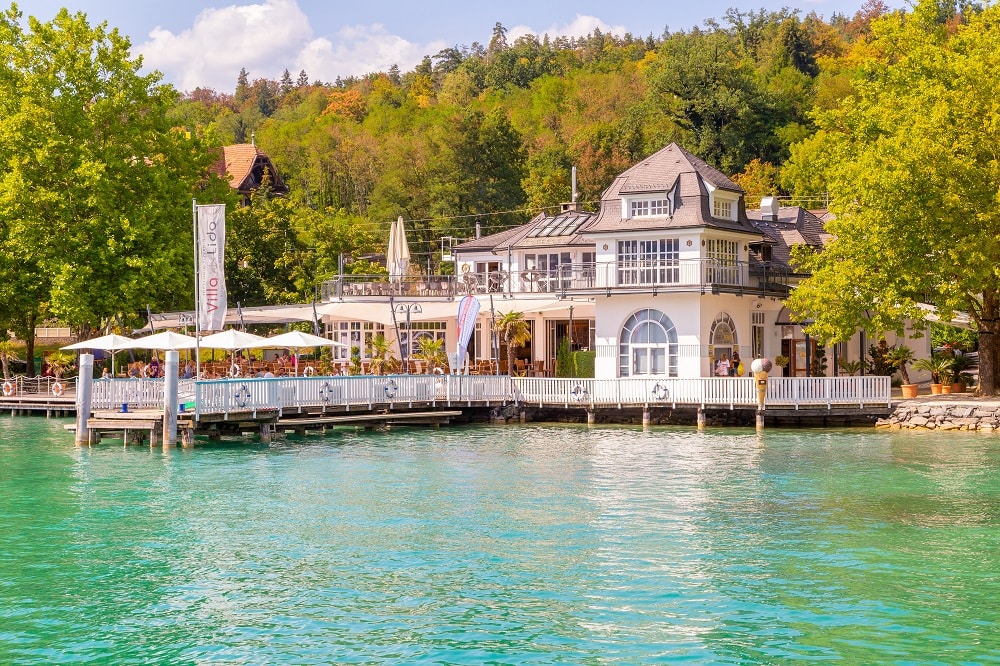 Blick auf die Villa Lido, im Vordergrund der türkisblaue Wörthersee