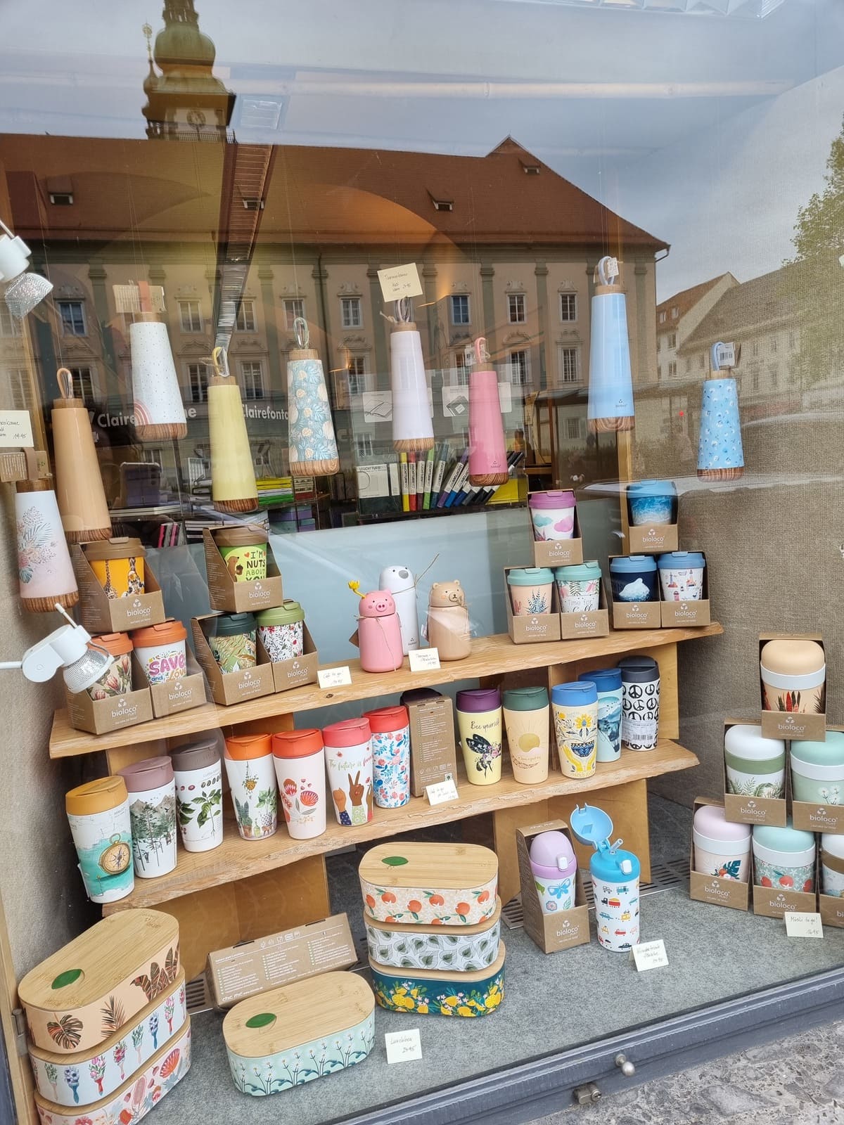 Schaufenster der Kärntner Buchhandlung mit vielen Schulartikeln zum Schulbeginn: Trinkflaschen, Jausenboxen, Warmhaltegefäße, Teebecher, Kaffeebecker