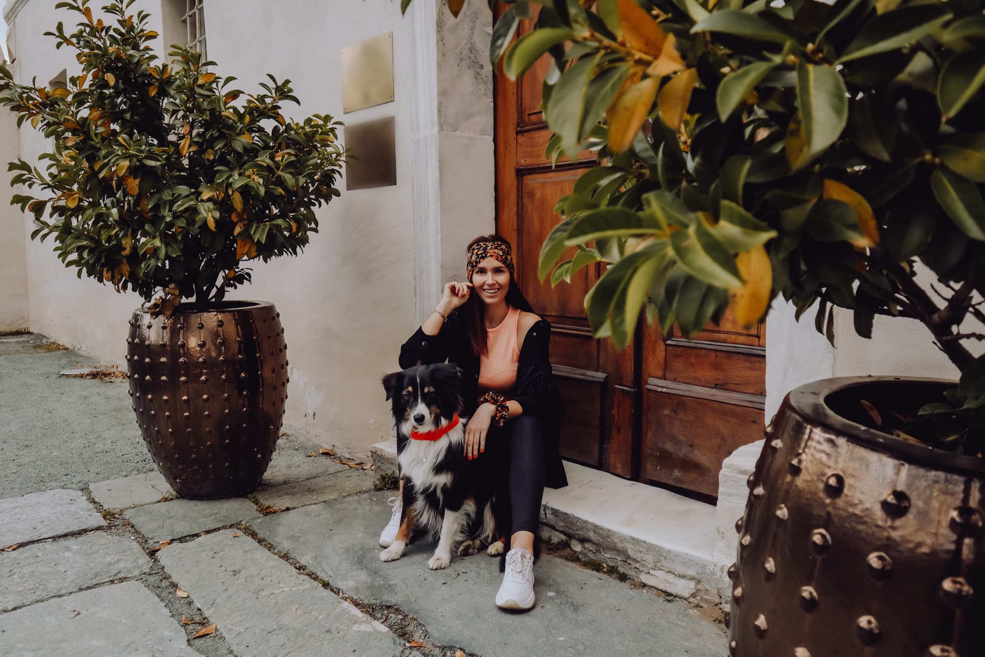 Selina Kutej mit Hund vor der Tür, sie trägt ein TINKA-Stirnband