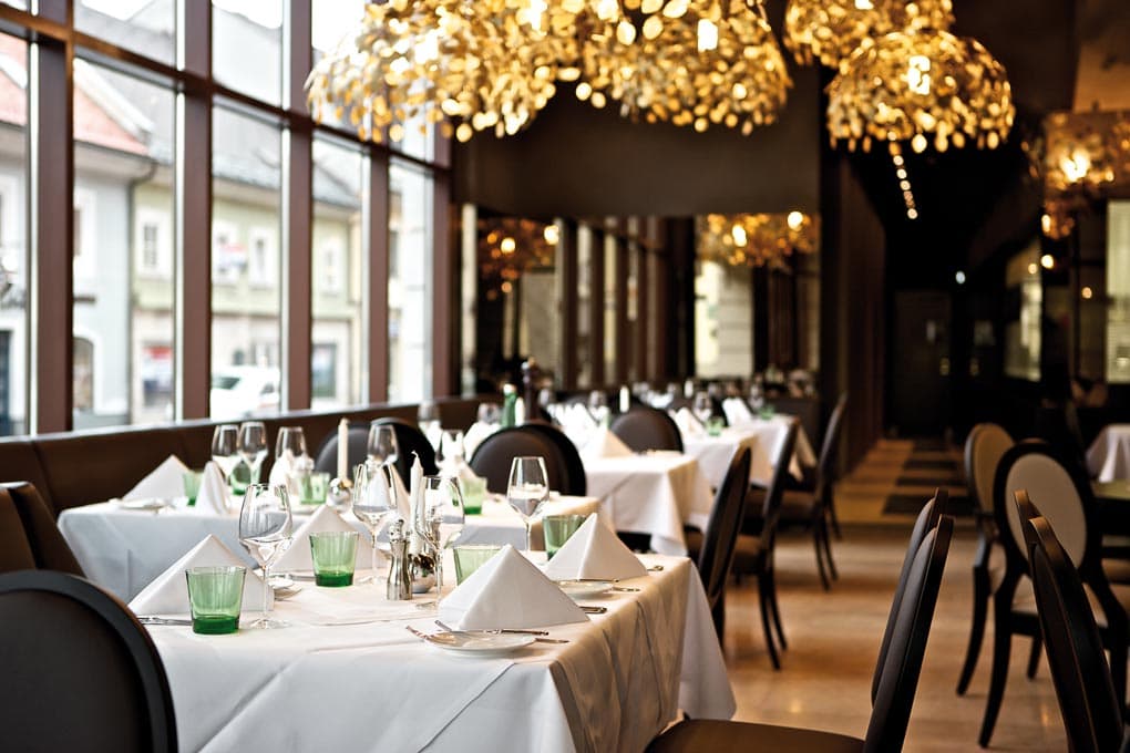 Gedeckte Tische und opulente Inneneinrichtung im Restaurant Oscar in Klagenfurt