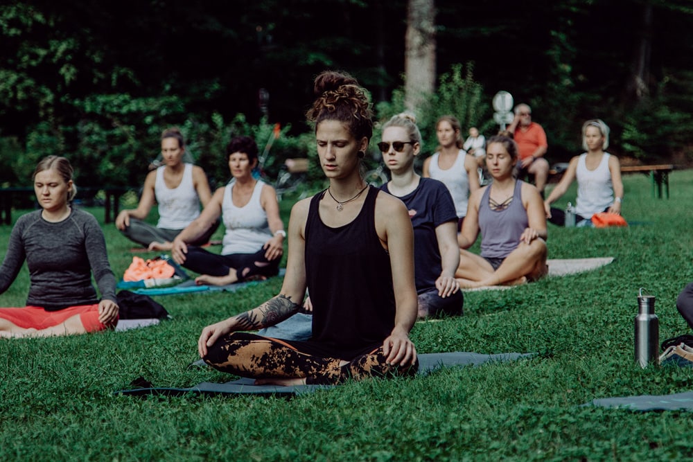 Yogis beim praktizieren in Meditationssitz im Park in Klagenfurt
