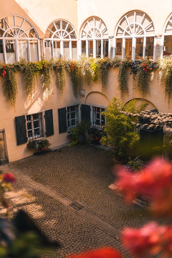 Innenhof mit Beblumung und großen halbrunden Fenstern im Bamberger Hof in Klagenfurt