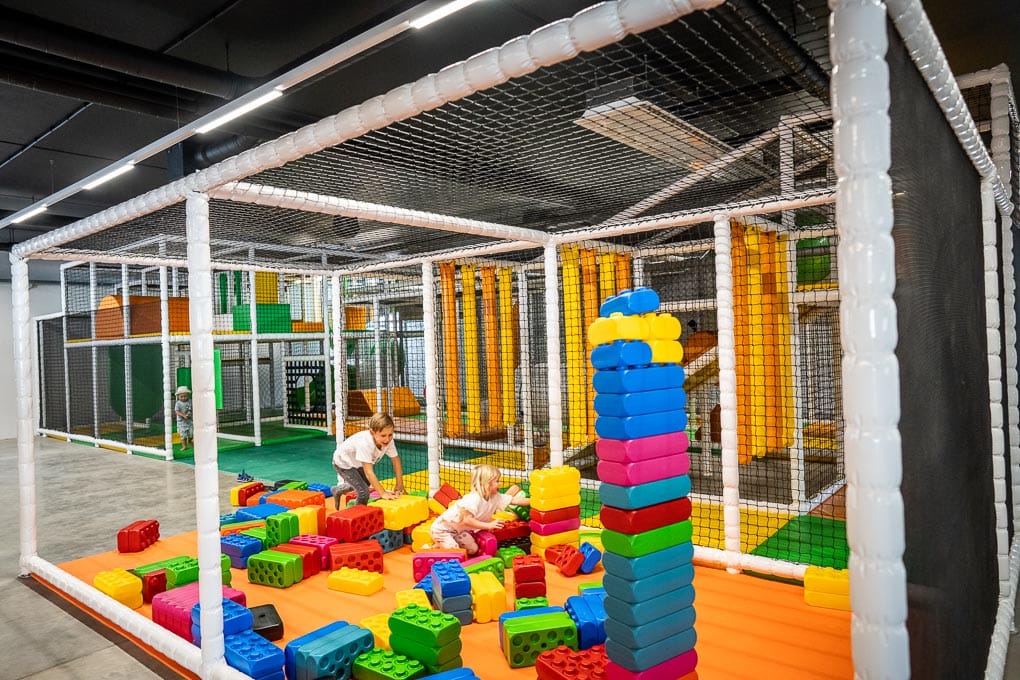 2 Kinder beim Spielen im Indoor Spielplatz mit großen Legosteinen bei JUMPWORLD.ONE in Klagenfurt