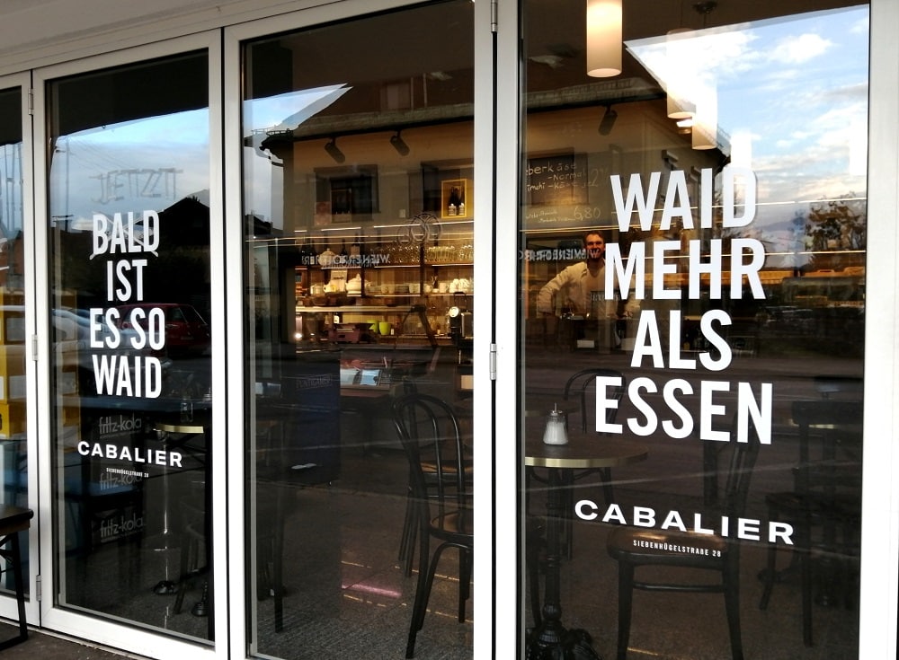 Eingangsportal des Lokals Cabalier in der Siebenhügelstraße in Klagenfurt Waidmannsdort mit der Aufschrift Waid mahr als Essen und bald ist es so waid