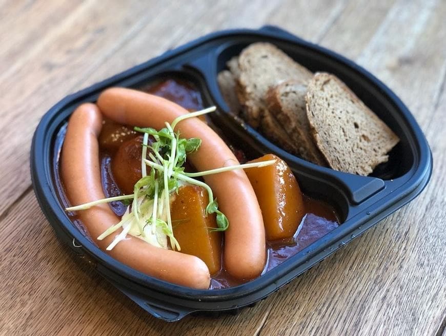 Kartoffelgulasch und Würstel mit Schwarzbrot von Papa Jo aus Klagenfurt, in einem Take Away Geschirr angerichter