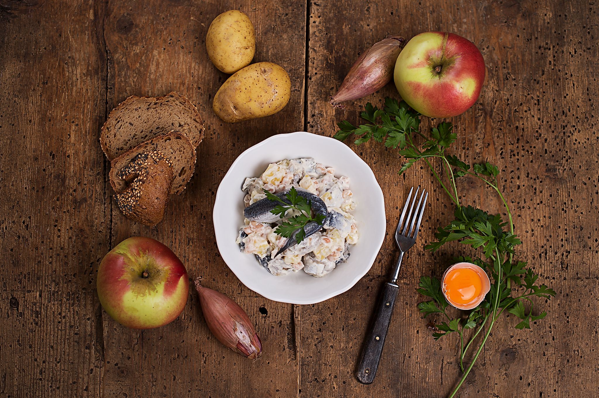 Heringssalat mit Kartoffeln, Apfel und Zwiebel und frischem Brot 