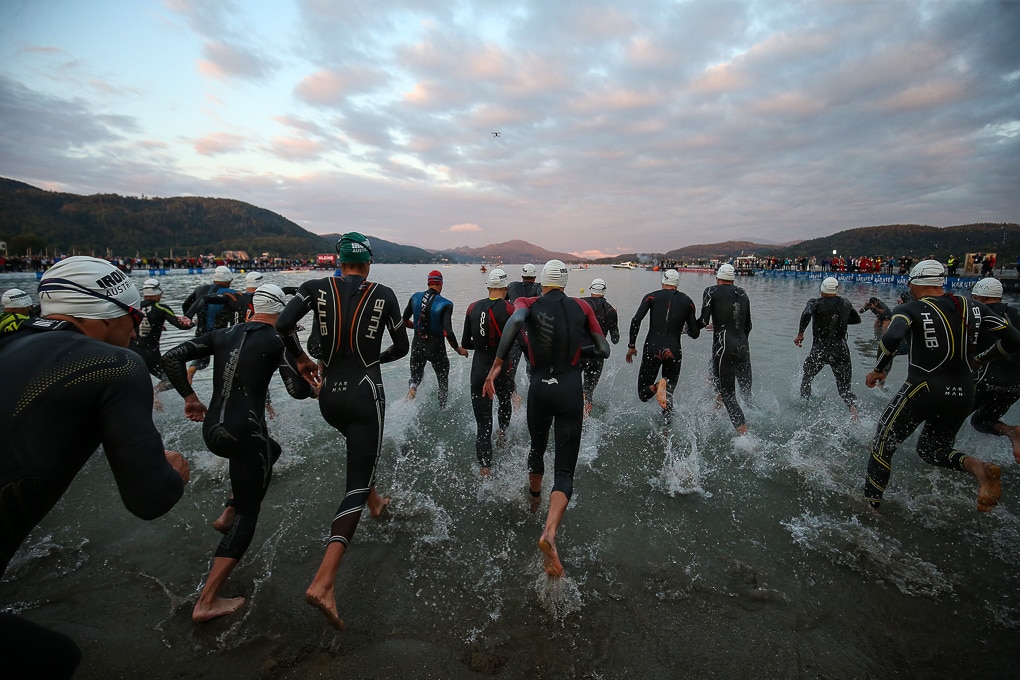 IRONMAN Teilnehmer laufen ins Wasser um Schwimmstrecke des Bewerbs zu starten