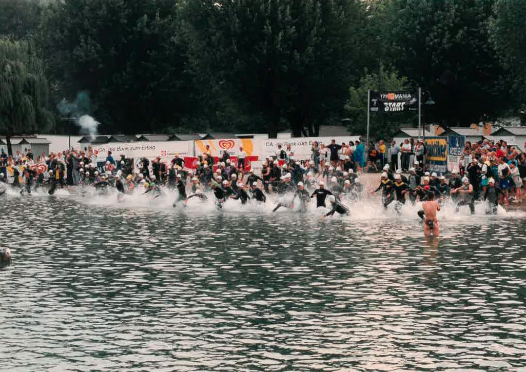 IRONMAN Teilnehmer laufen ins Wasser um die Schwimmstrecke des Wettbewerbs zu starten 