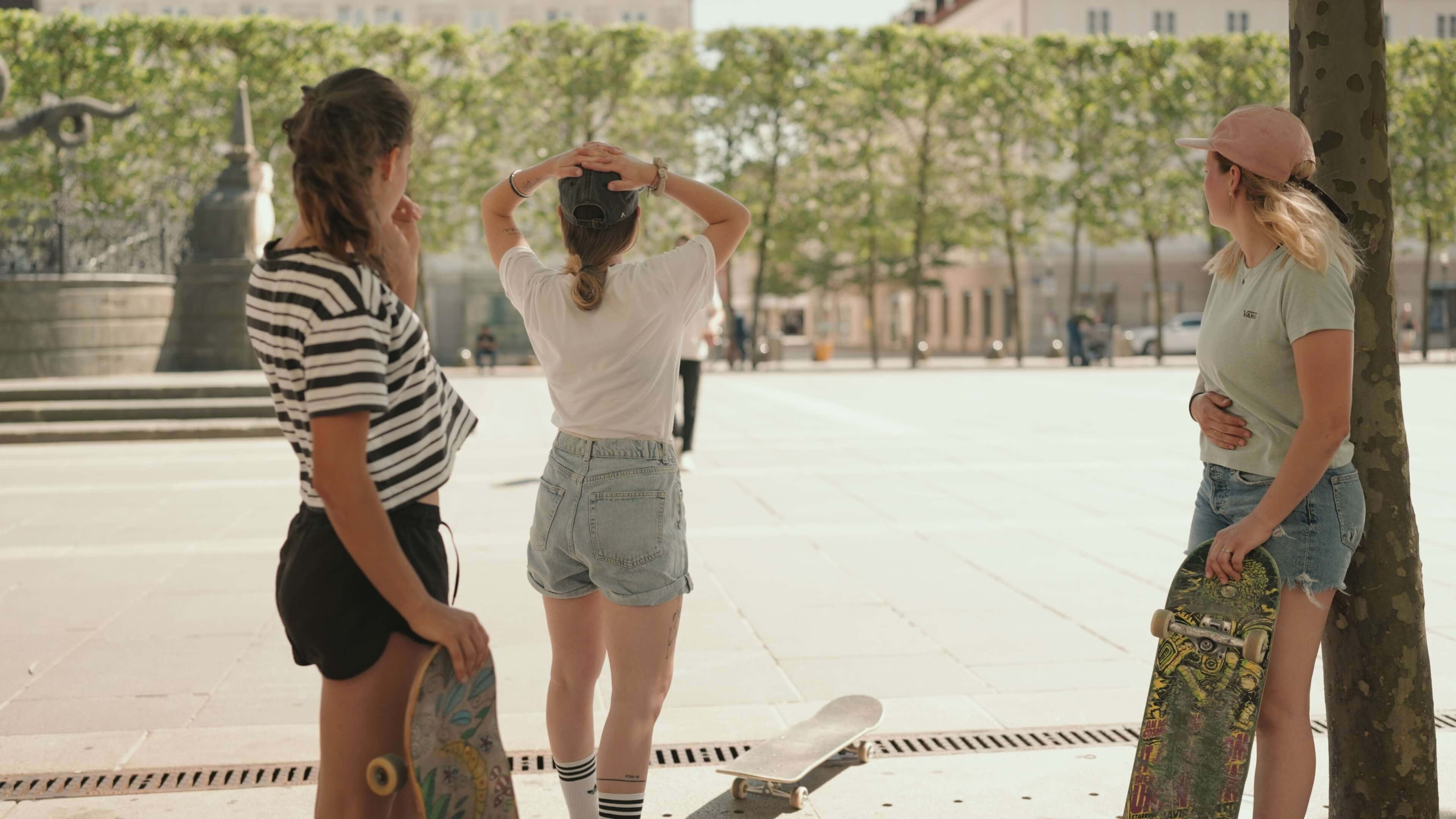 Skaterinnen in Shorts und T-Shirts mit ihren Skateboards