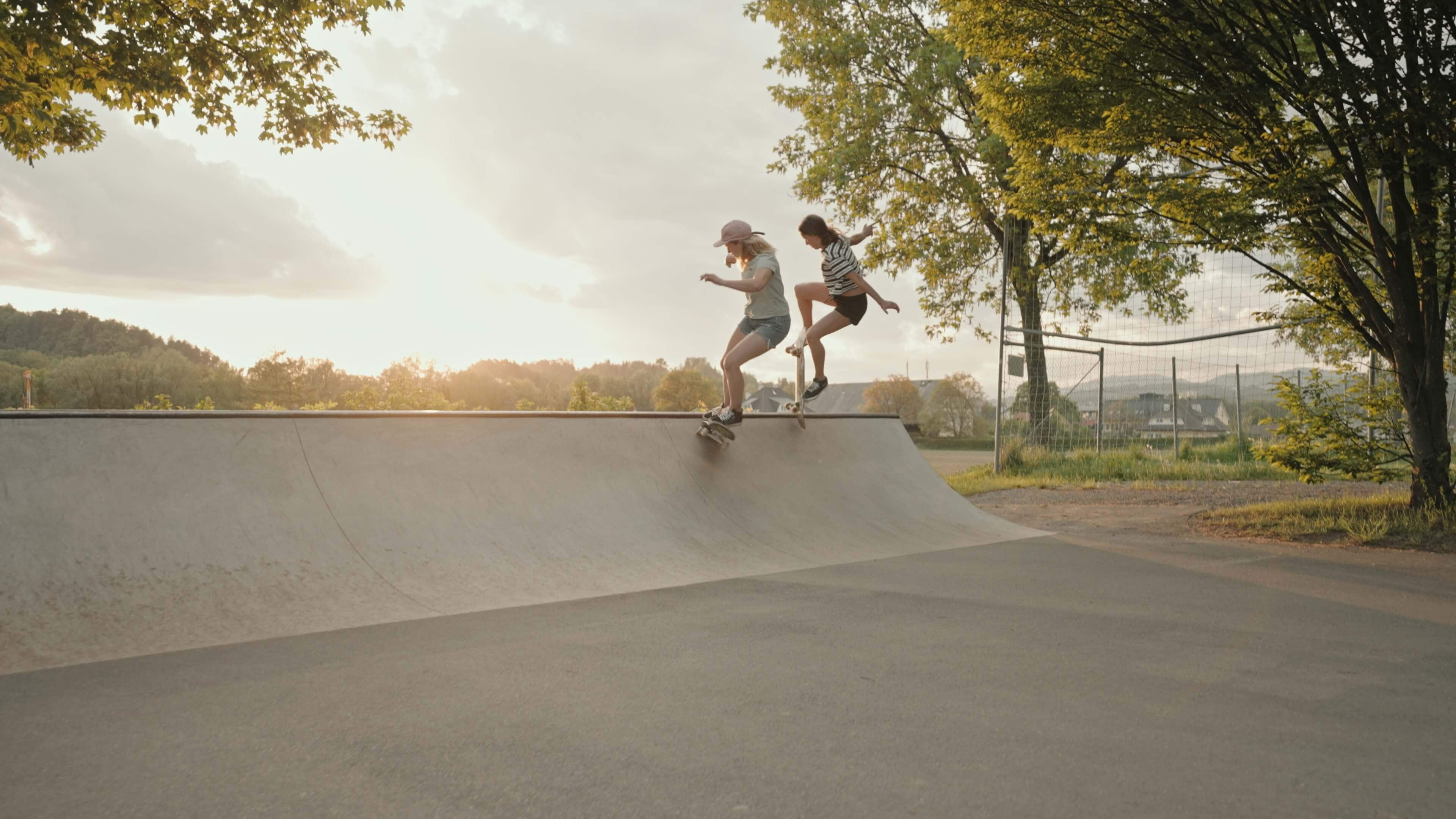 Zwei Skaterinnen beim Skaten am frühen Abend im Skatepark Feschnig