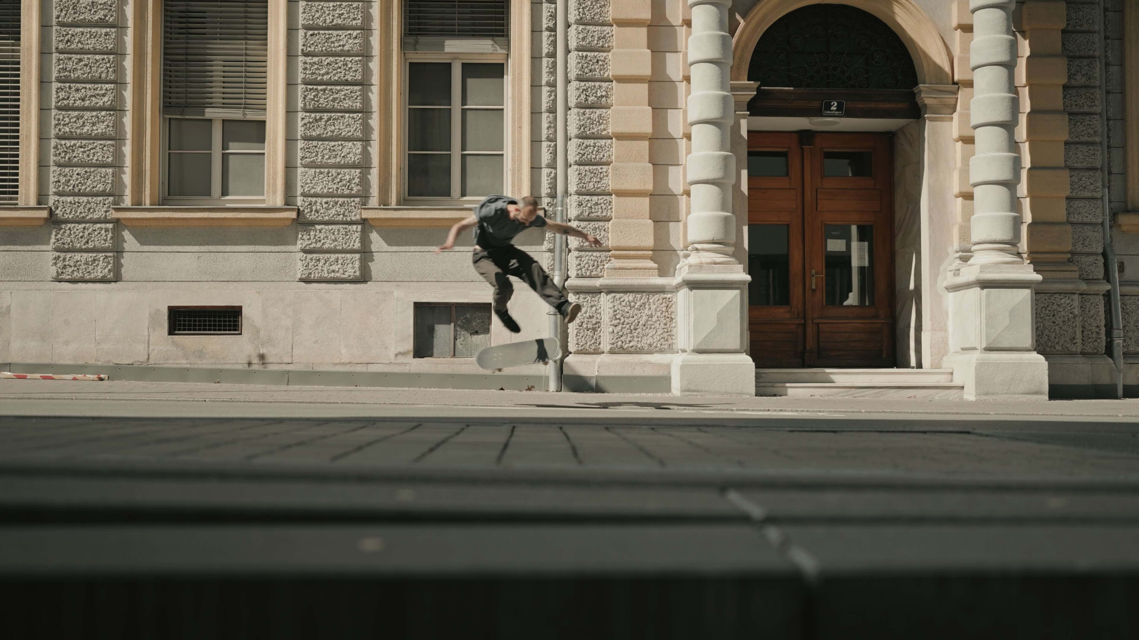 Skater macht Flip mit Skateboard auf Straße 
