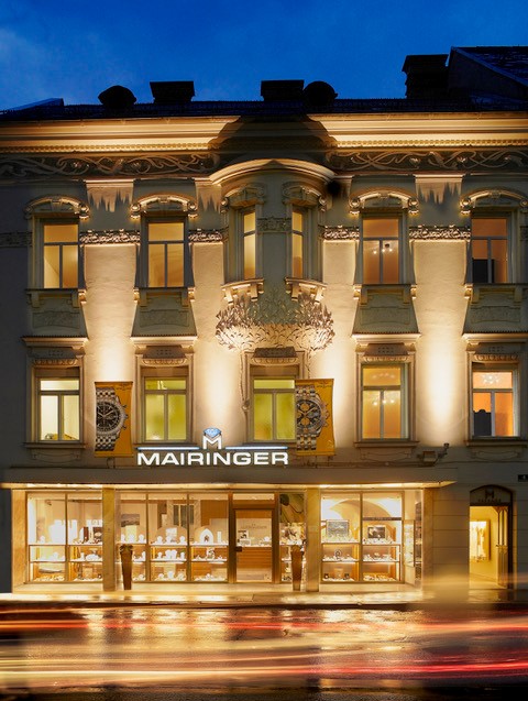 Die nächtlich beleuchtete Fassade von Juwelier Mairinger in Klagenfurt heute