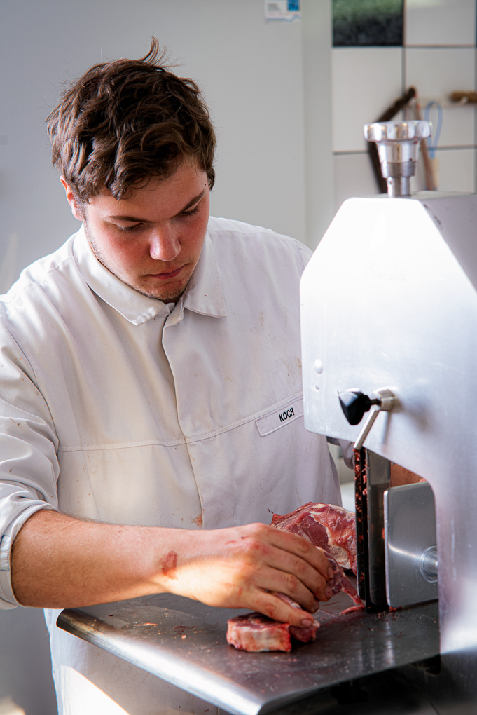 Metzger beim Fleischschneiden mit der Maschine 