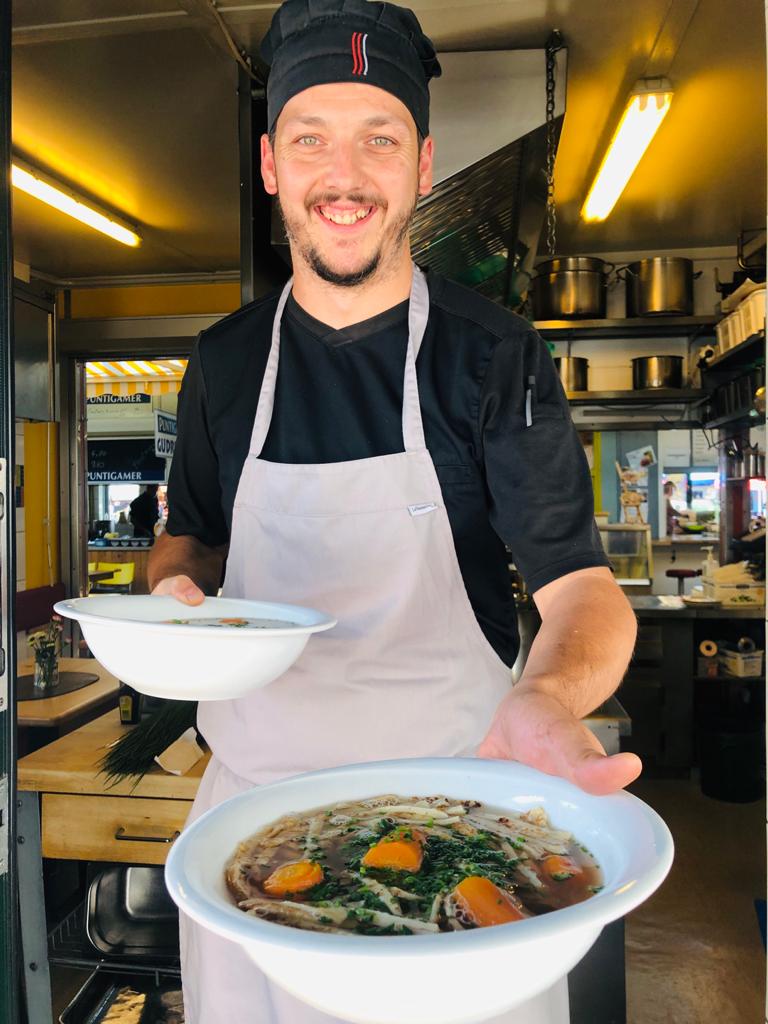 Andi Schöffmann, Chef des Marktlokals "Bei Rudis" am Benediktinermarkt, beim Ausgeben einer großen Fritattensuppe