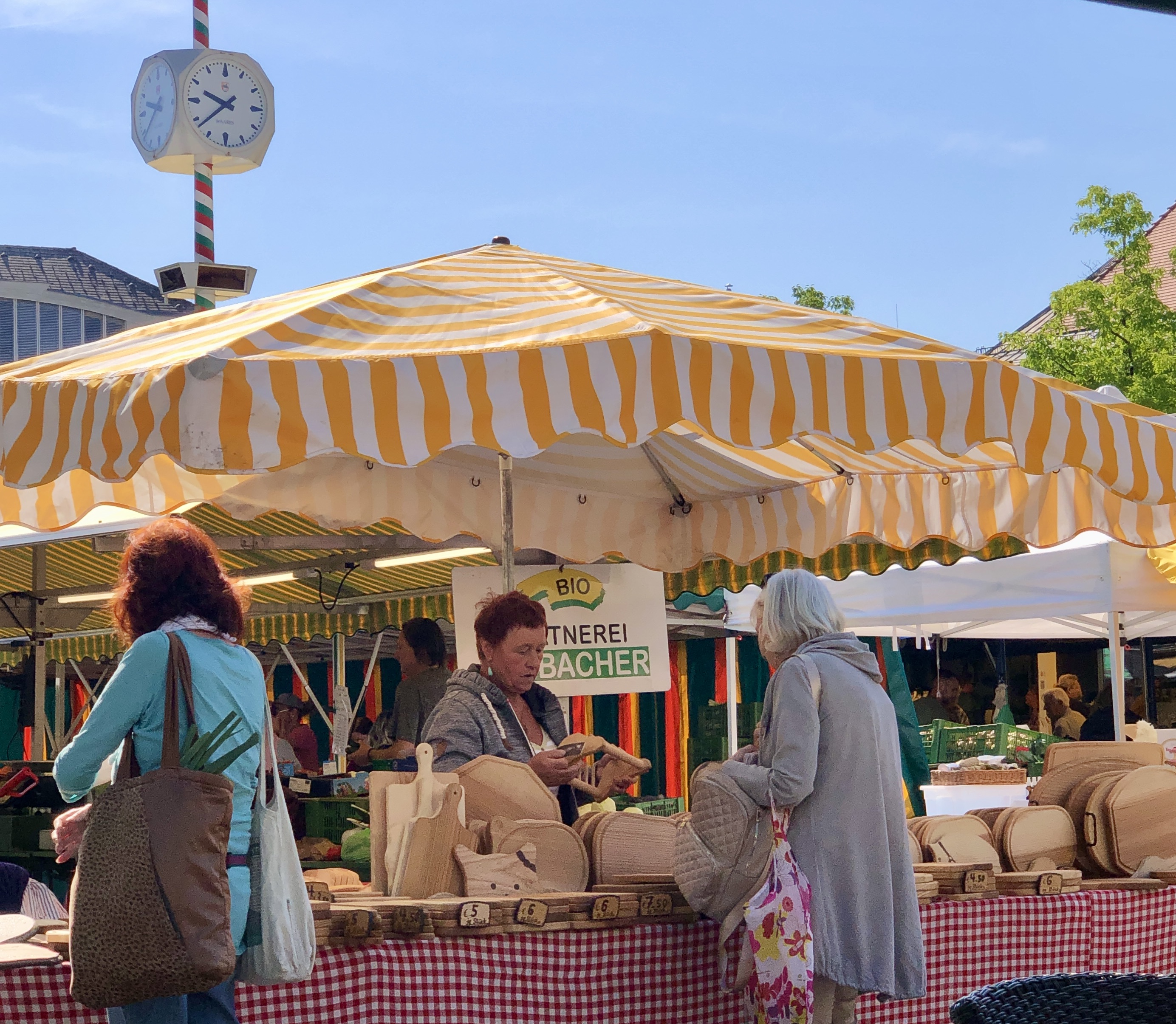 Dame beim Einkaufen von Holzschneidebrettern am Benediktinermarkt in Klagenfurt