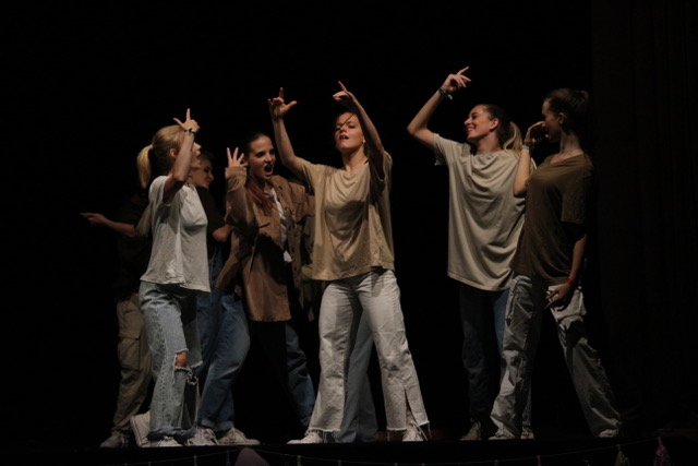 Eine Tanzgruppe von "FAM of Arts" auf der Bühne, sie tragen weite T-Shirts in beige-Tönen und löchrige Jeans