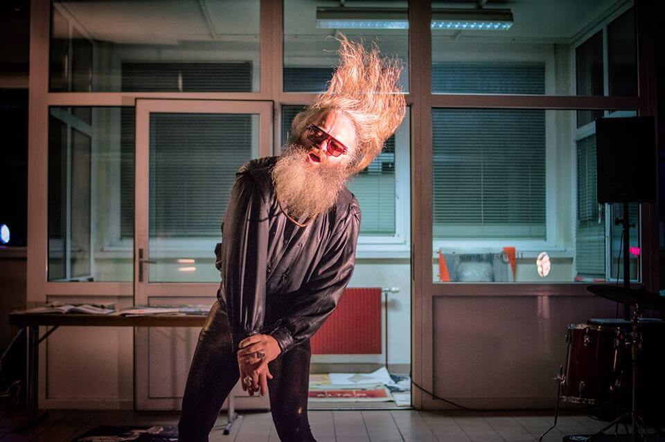 Performance Künstler mit langem Bart und Haaren in der Luft im Dark City - raum0 in Klagenfurt