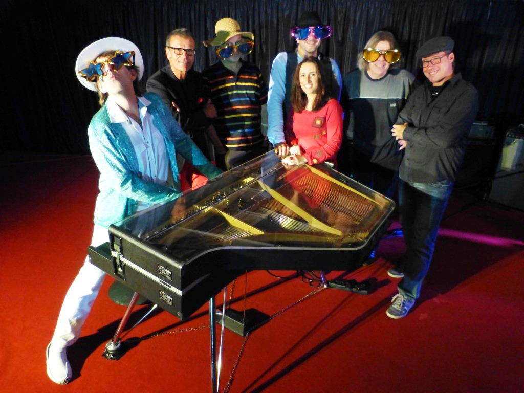 Die "Tribute to Elton John"-Band steht um ein Keyboard auf der Bühne des Eboardmuseums Klagenfurt