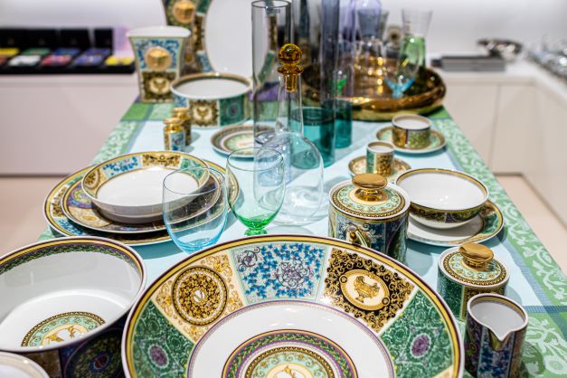 ein gedeckter Tisch mit blau-gold-grünem Porzellan-Service