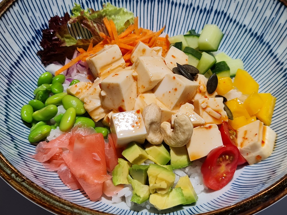 Bowl mit Avocado, Blattsalat, Gurke, Paprika, Tomate, Bohnen und Tofu 