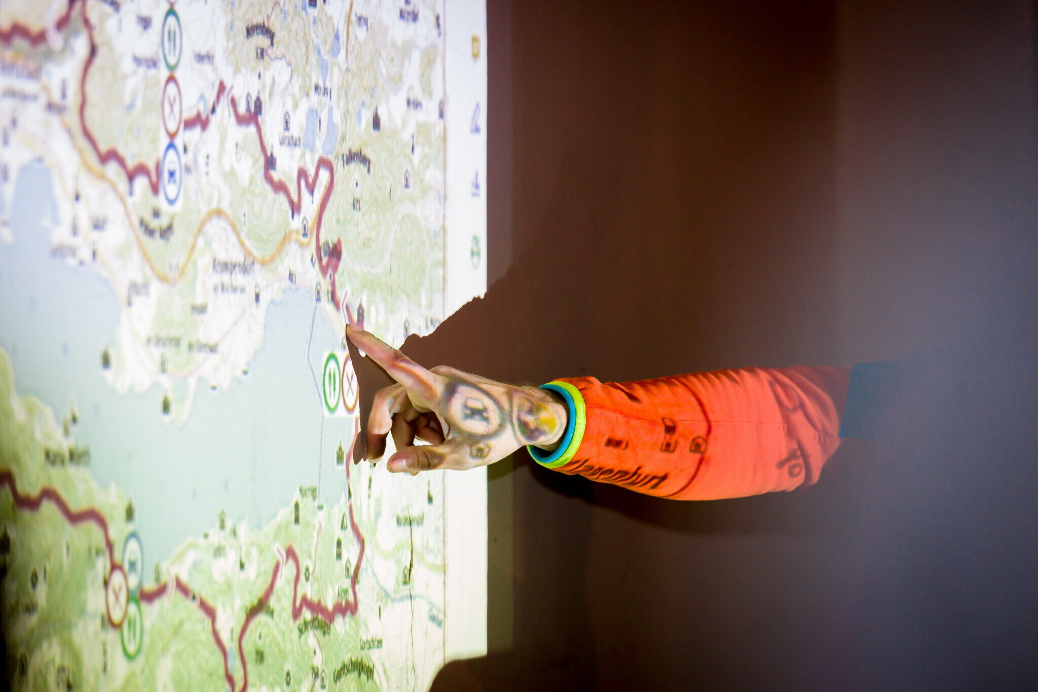 Person zeigt auf eine Wanderkarte mit eingezeichneter Wanderroute rund um den Wörthersee 