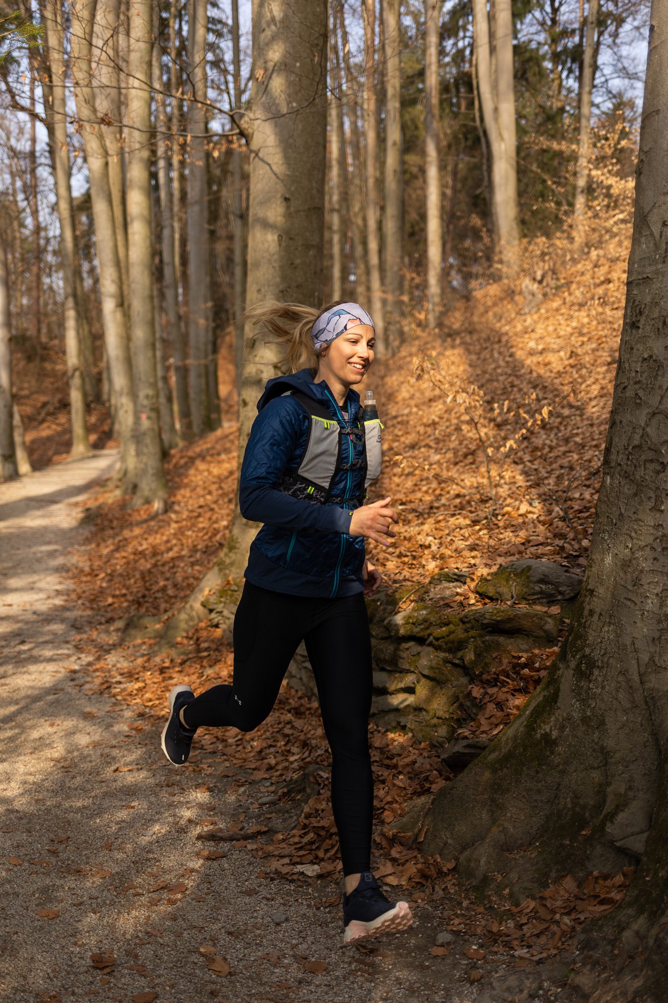 Trail Läuferin beim Laufen auf Waldweg im Herbst 