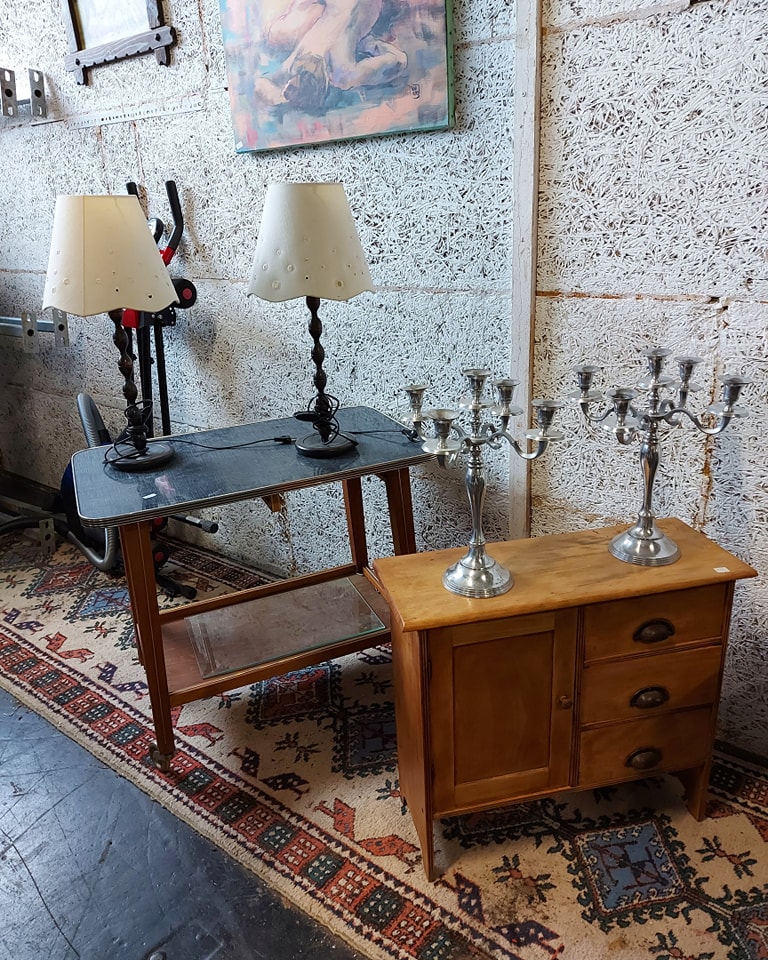 Kleine Kommode und kleiner Tisch mit alten Kerzenständern und Tischlampen darauf, Stücke aus der Sirius Flohmarkthalle Klagenfurt