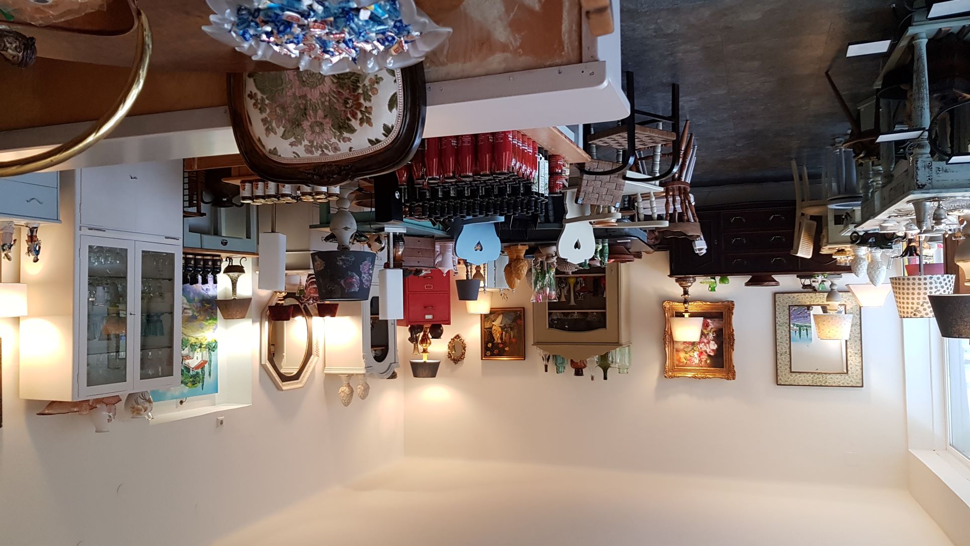Der Verkaufsraum von Homeart mit vielen restaurierten Altmöbeln sowie Lampen, Gemälden und Genussprodukten auf den Tischen