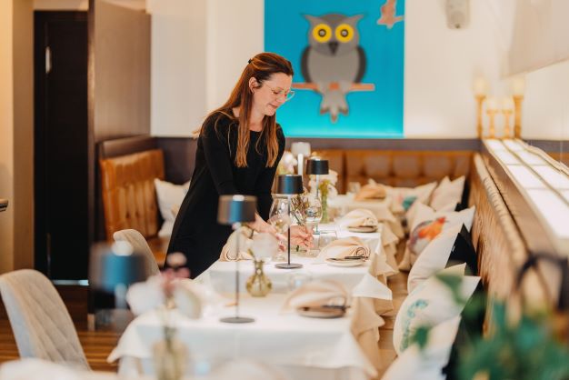 Vogelhaus-Inhaberin Stefanie Falckenberg beim Aufdecken der Galatische in ihrem Restaurant