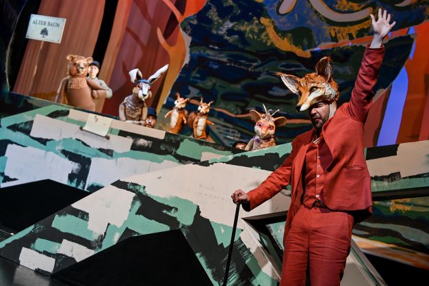 Protagonist des Kinderstücks "Klettermaus und die Tiere vom Hackebackewald" am Stadttheater Klagenfurt im Vordergrund der Bühne, Tier-Puppen im Hintergrund