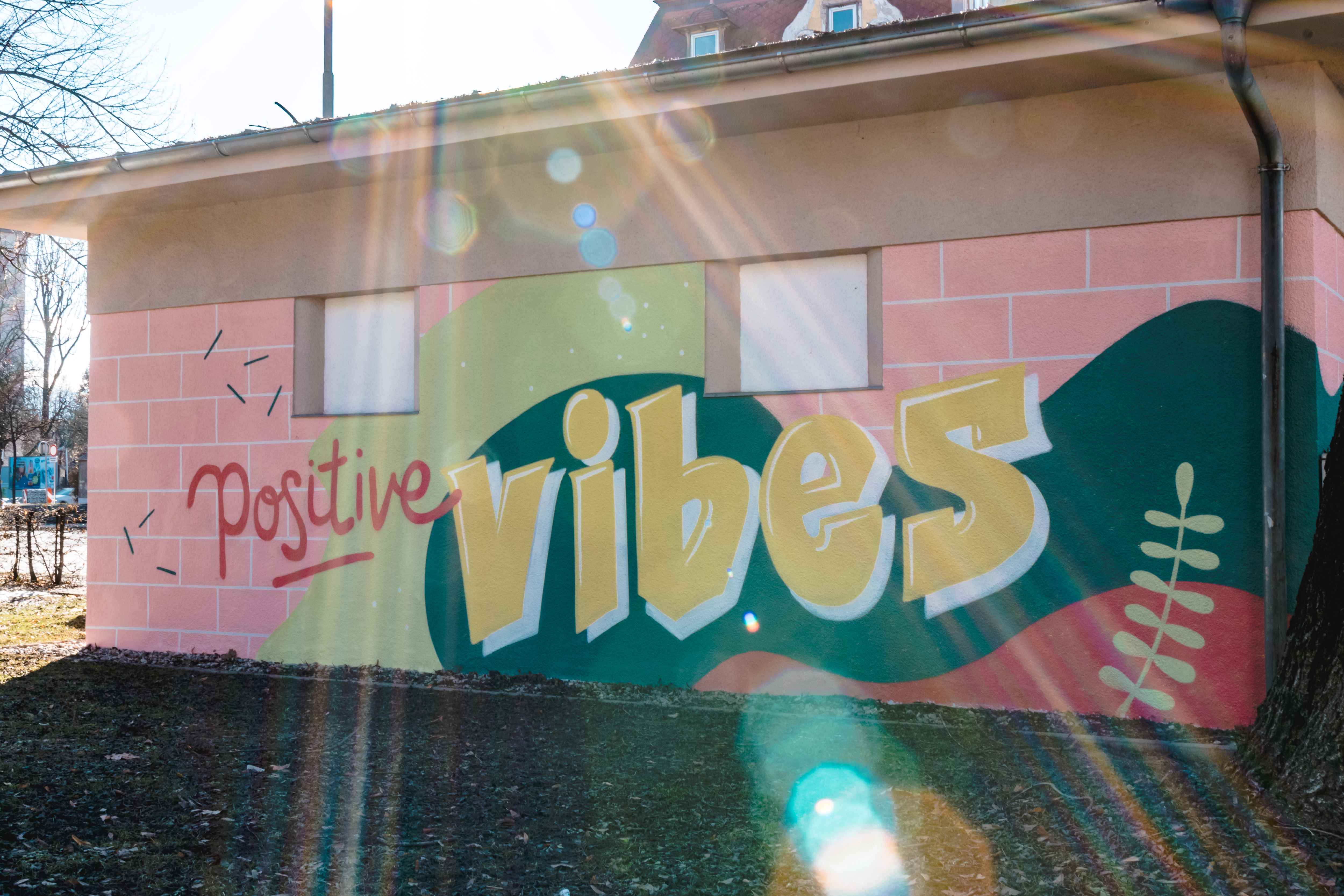 Graffiti imBuntes Klagenfurter Schillerpark, mit dem Schriftzug "Positive Vibes"