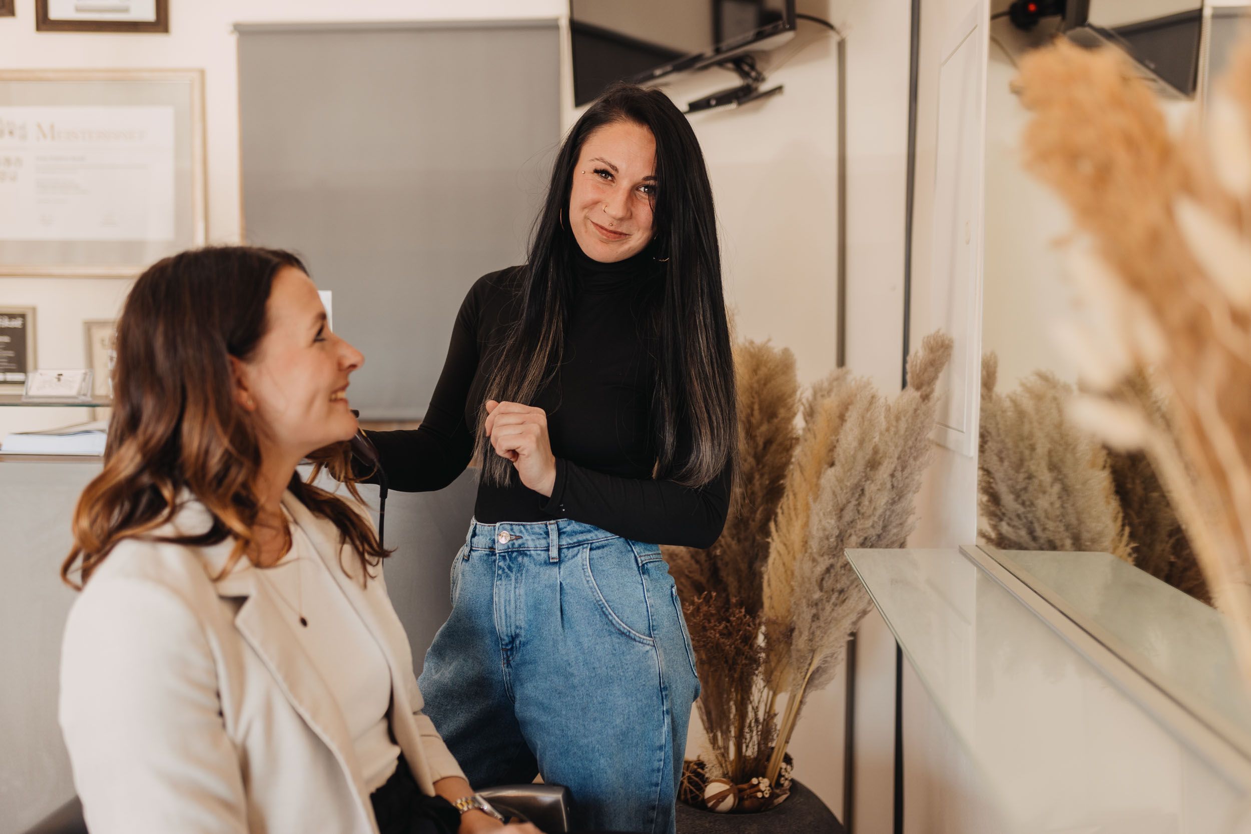 Friseurin "Die Schnitte" Patricia Knafl in schwarzem Pulli und Jeans bei der Beratung einer Kundin