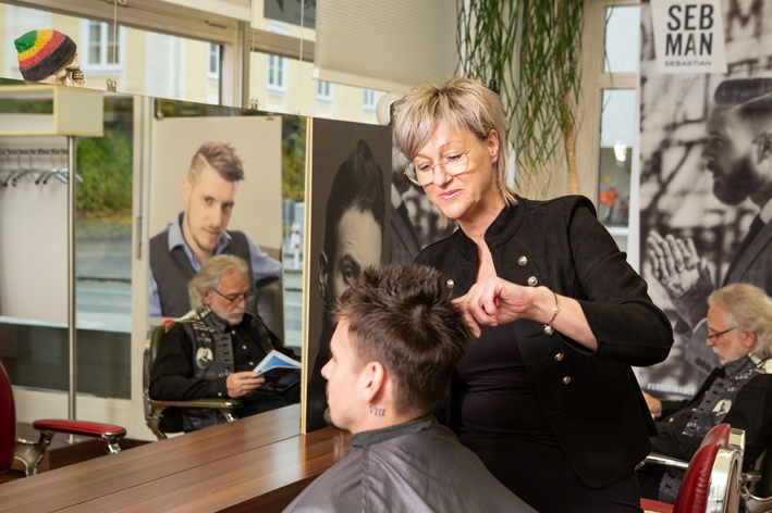 Dunja, Stylistin im Salon Haarisma, schneidet einem jungen Mann die Haare