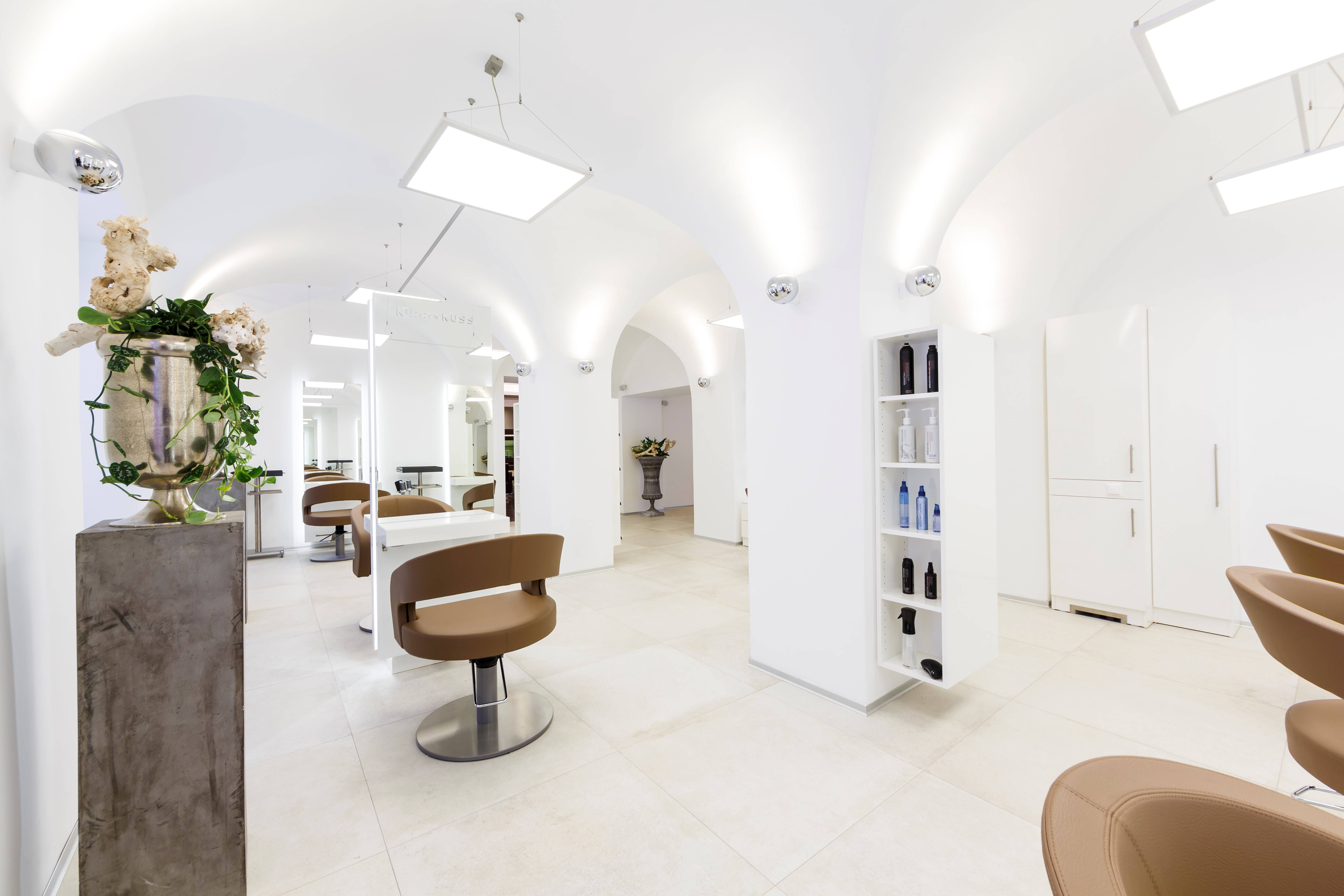 Blick in den hellen, mit Bögen ausgestalteten Frisiersalon der Friseure Kuss & Kuss