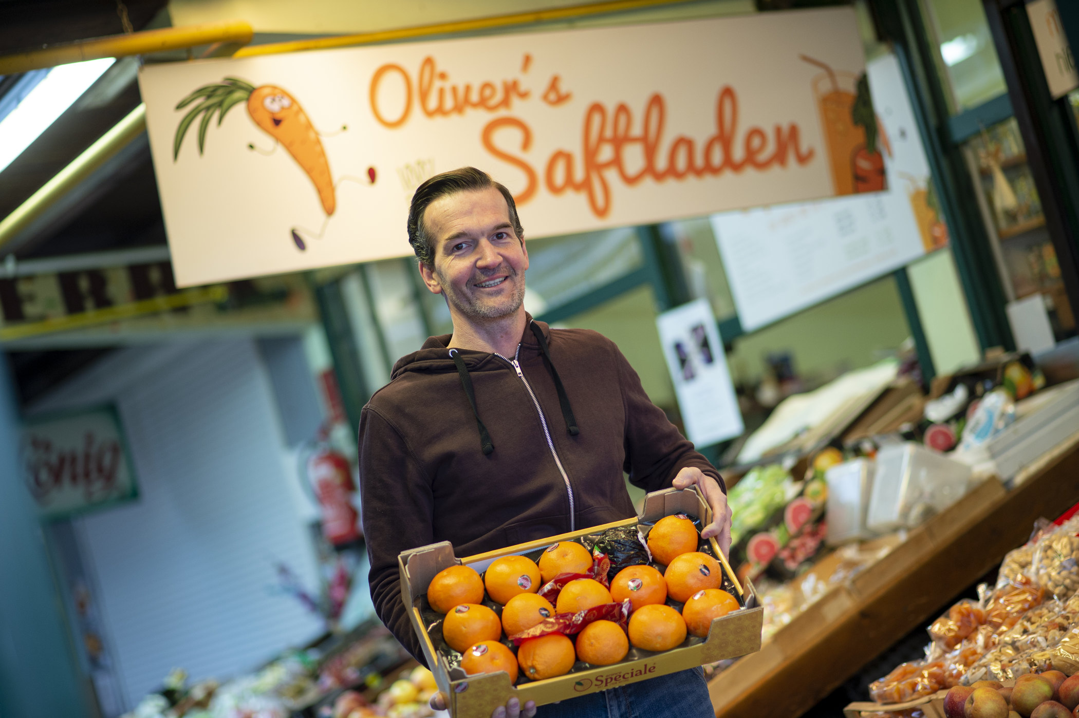 Oliver Ferra, Betreiber von Olivers Saftladen am Markt in Klagenfurt, mit einer Steige Orangen