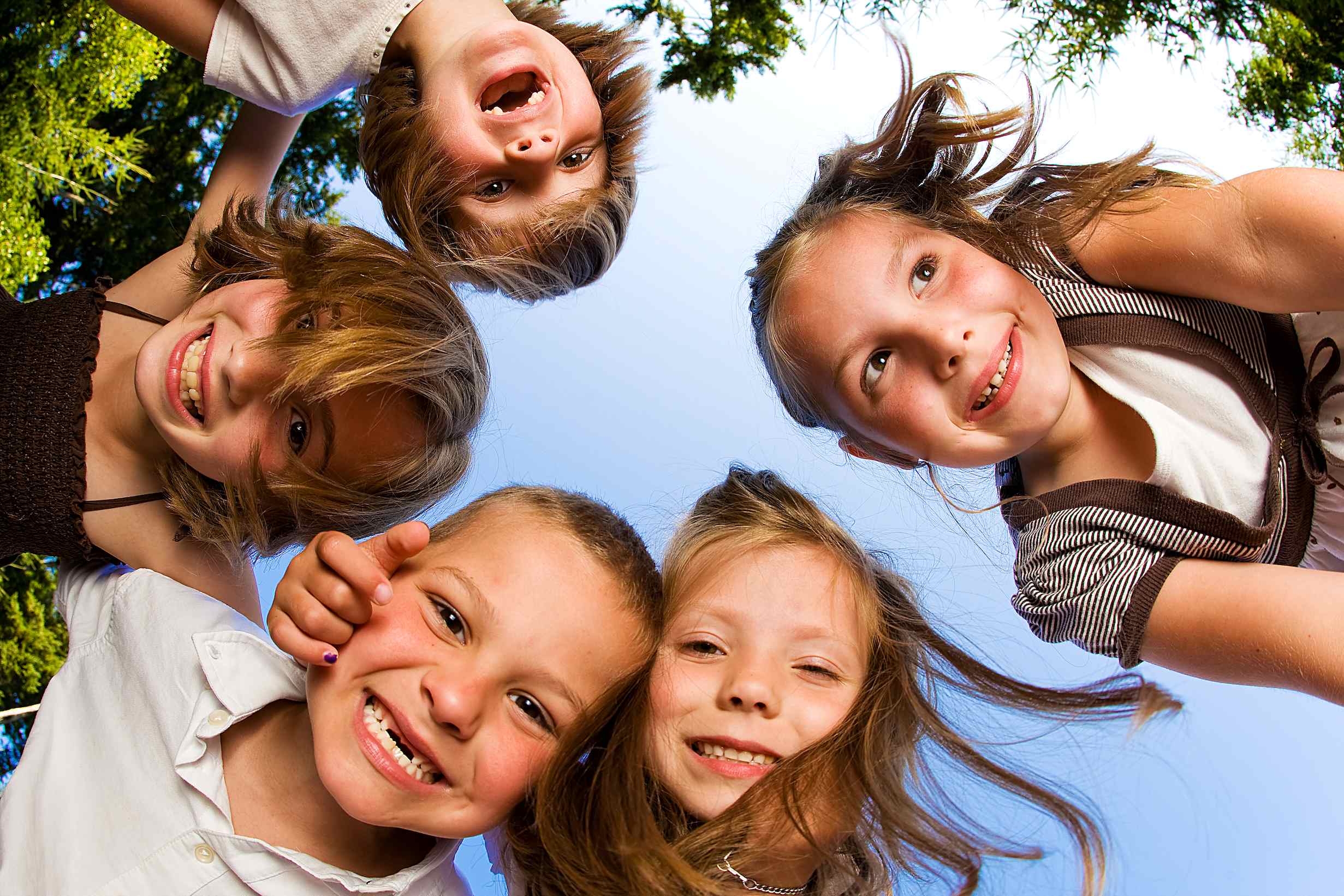 Kinder stehen im Kreis und lächeln ins Bild