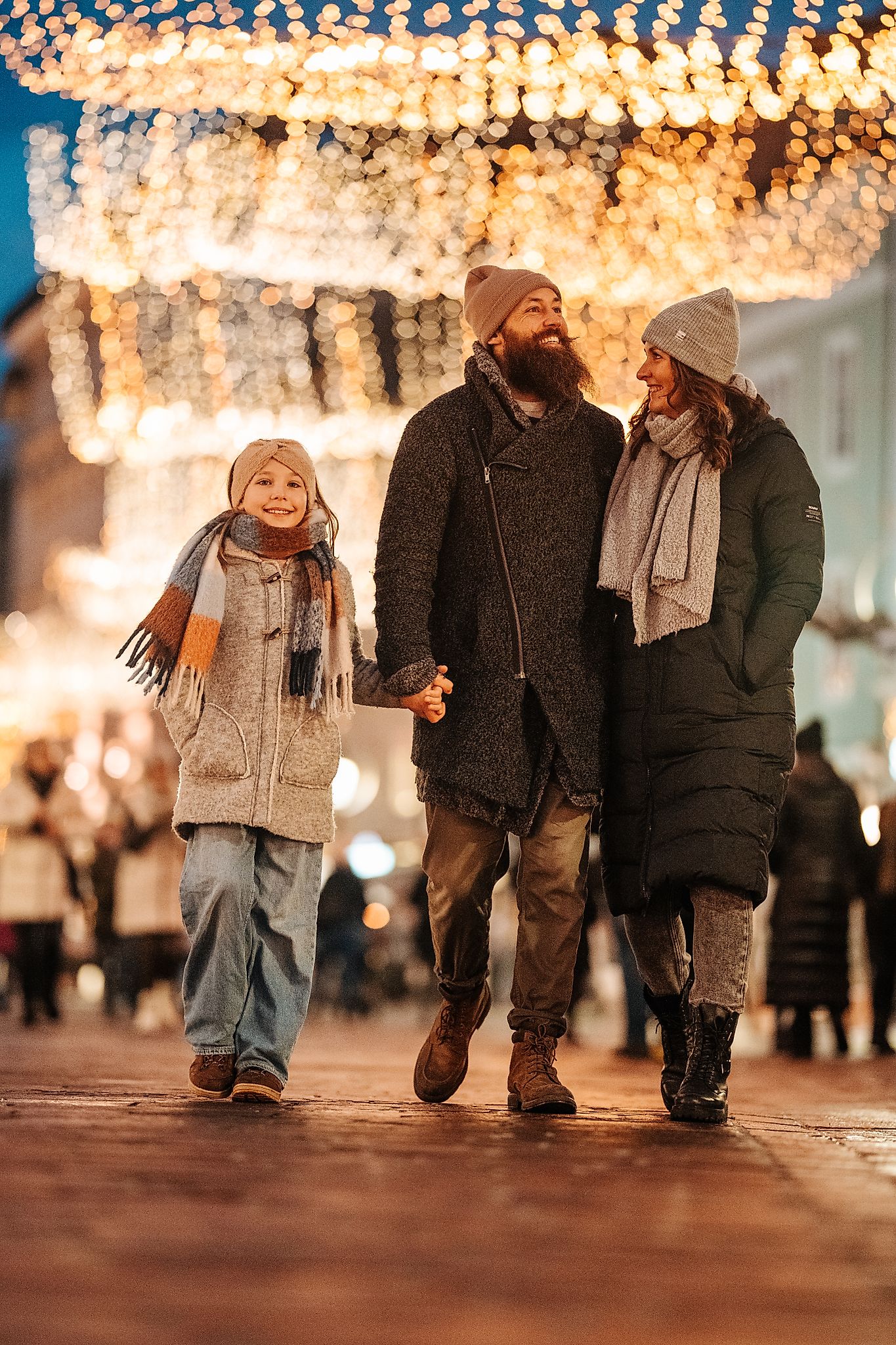 Paar mit Tochter beim Spaziergang durch die Klagenfurter Altstadt mit Weihnachtslichtern