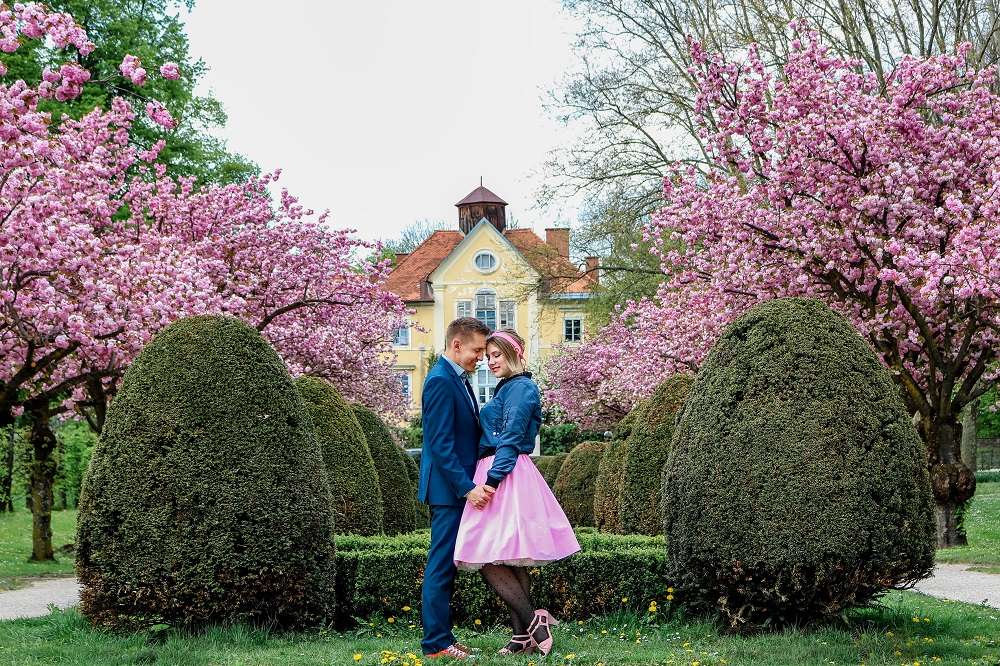 Junges Pärchen im Goethepark Klagenfurt, Herbertstöckl und Kirschblüte im Hintergrund