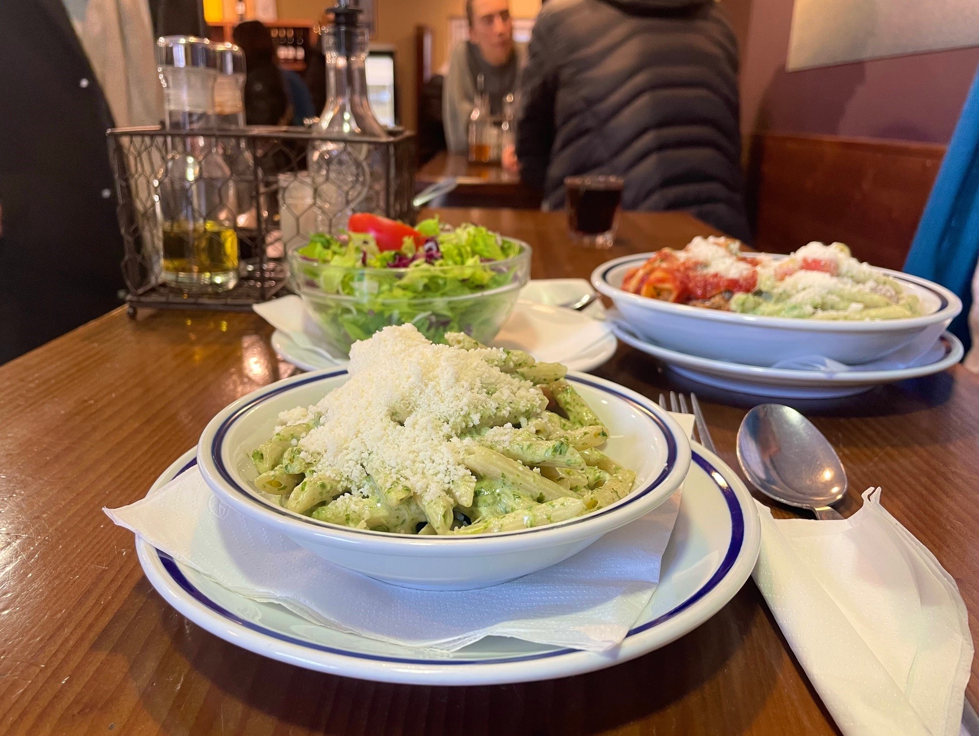 Penne und Insalata Mista auf einem Holztisch im La Pasta Klagenfurt